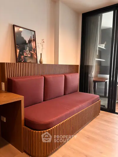 Modern living room with stylish wooden furniture and cozy red sofa, featuring elegant decor and natural light.