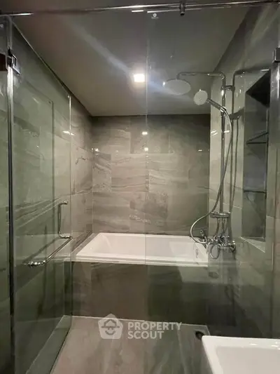 Luxurious modern bathroom with sleek glass shower and elegant bathtub.