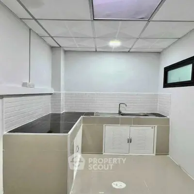 Modern kitchen with sleek countertops and white tile backsplash