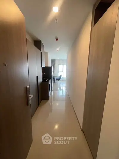Modern apartment hallway leading to a bright living area with sleek design.
