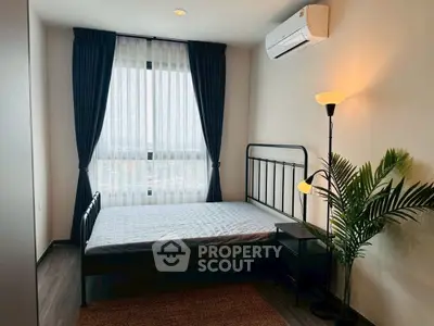 Cozy bedroom with large window, modern decor, and air conditioning unit.