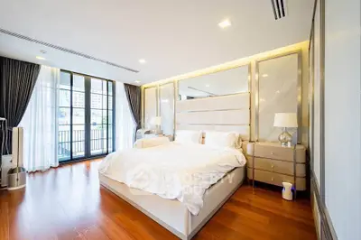 Luxurious bedroom with elegant decor and large windows offering city views.