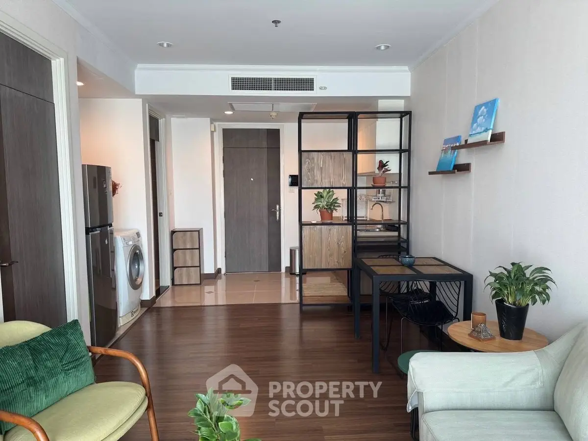 Modern living room with stylish furniture and appliances, featuring a washing machine and fridge.