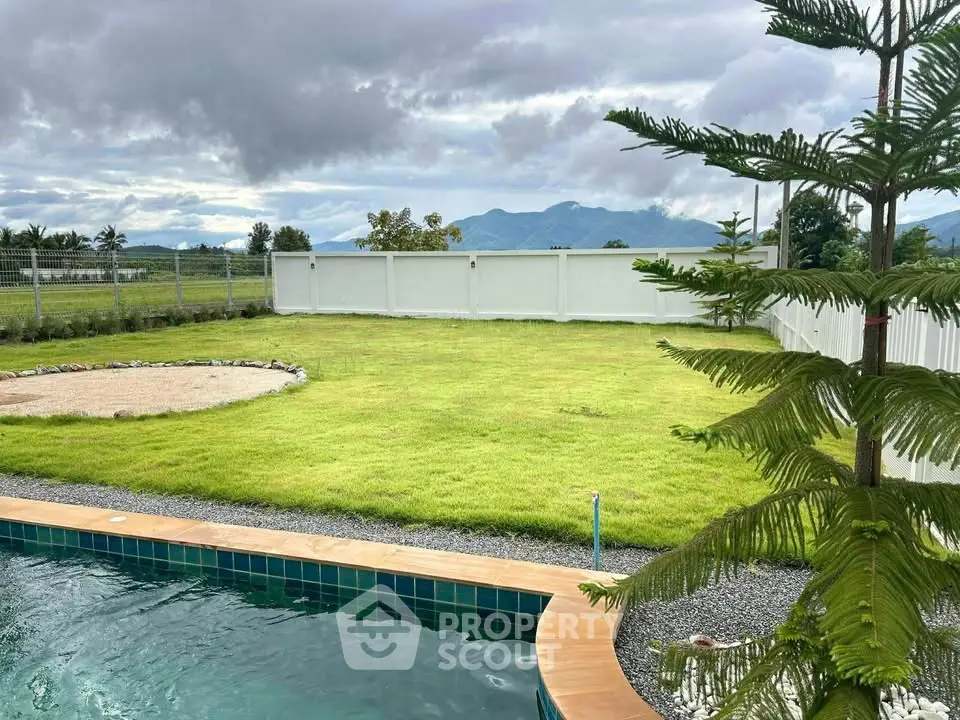 Spacious backyard with lush lawn and inviting pool, offering serene mountain views.