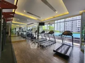 Modern gym with treadmills and large windows overlooking a pool and cityscape.