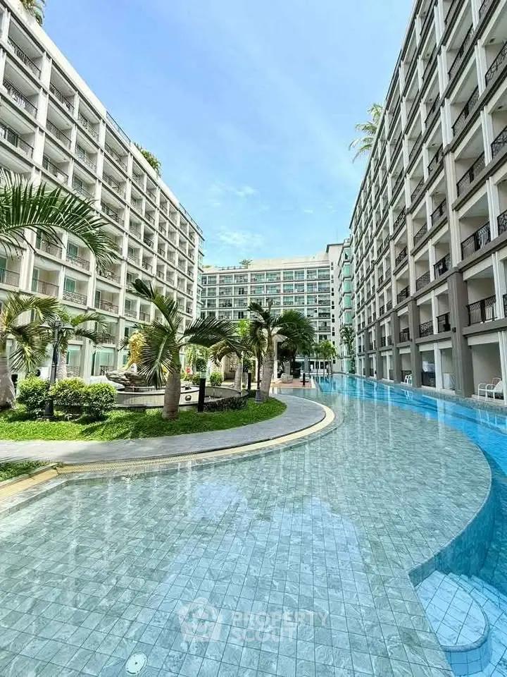 Luxurious resort-style apartment complex with stunning pool and lush greenery.