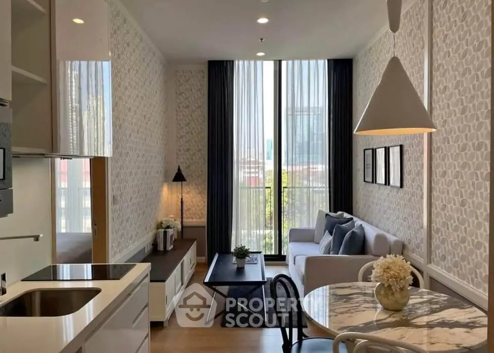 Stylish modern living room with open kitchen, elegant decor, and large window for natural light.