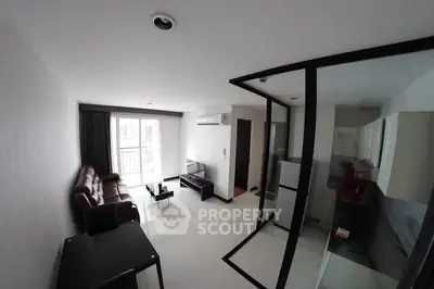 Modern living room with sleek design and glass partition, featuring a cozy sofa and flat-screen TV.