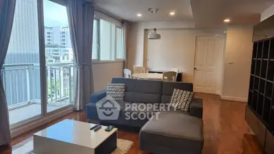 Spacious living room with modern decor and large windows in a stylish apartment.