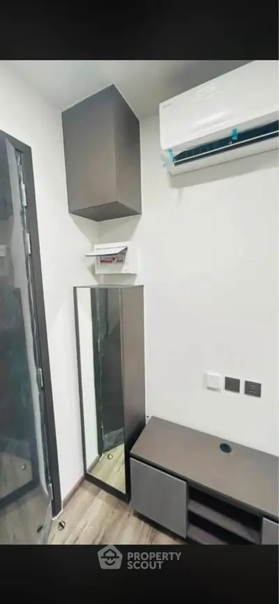 Modern compact room with air conditioning and sleek storage solutions.