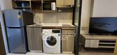Modern compact kitchen with washing machine and microwave in stylish apartment