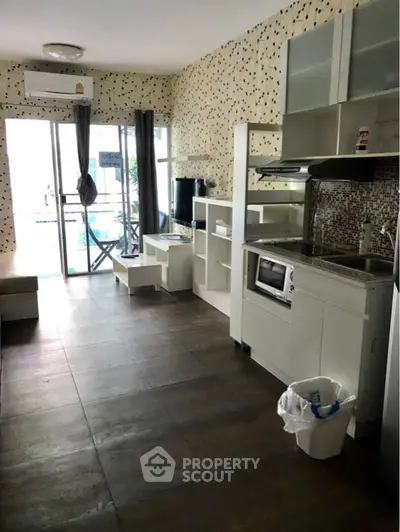 Modern kitchen with open layout and pool view, featuring sleek appliances and stylish decor.