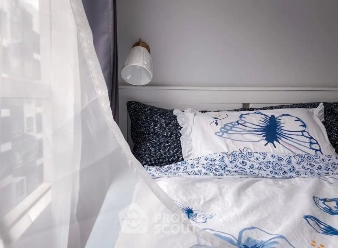 Cozy bedroom with elegant blue floral bedding and soft natural light