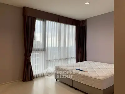 Spacious bedroom with large window and elegant curtains in modern apartment