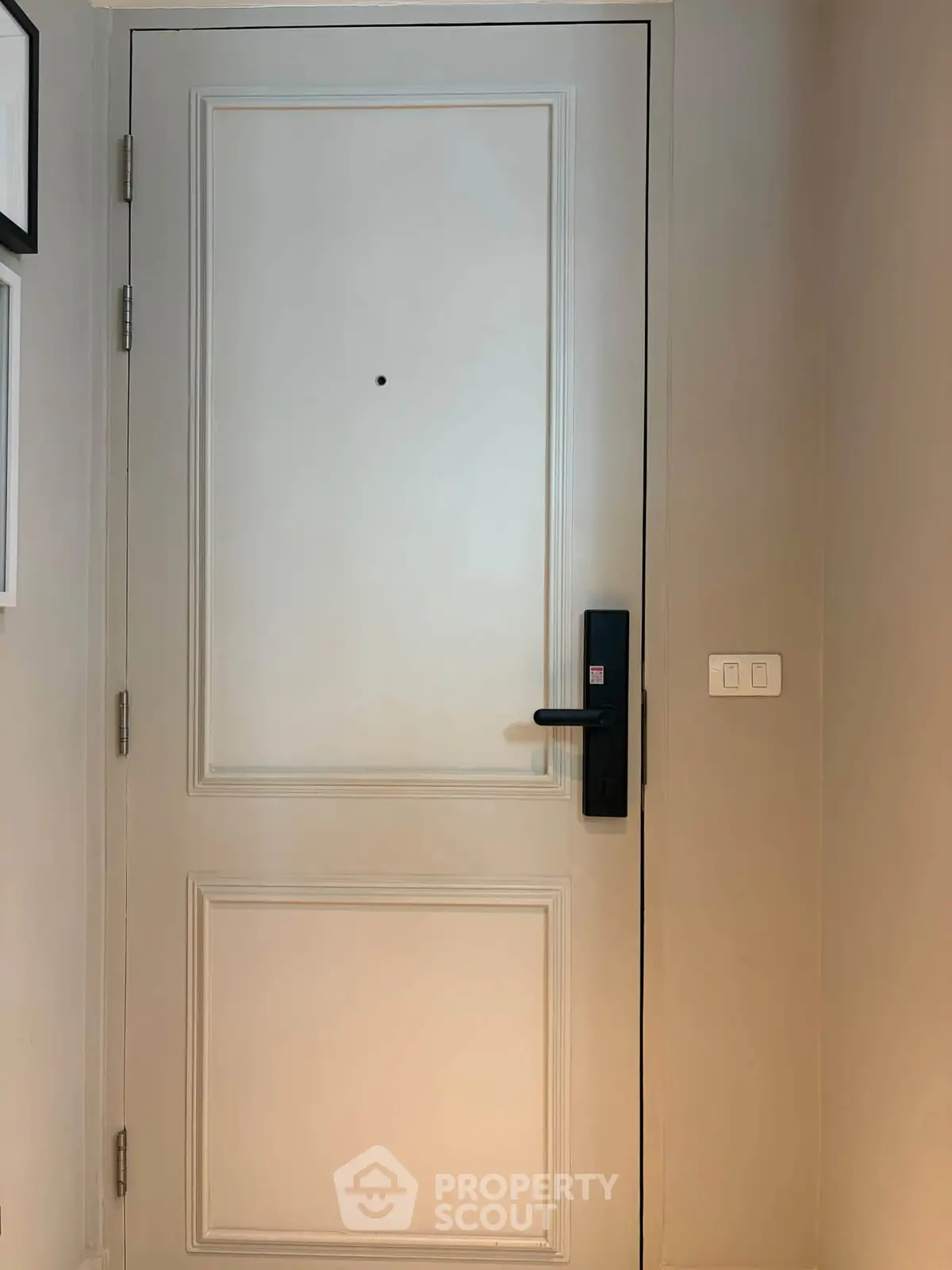 Elegant white entrance door with modern black handle in a stylish interior setting.