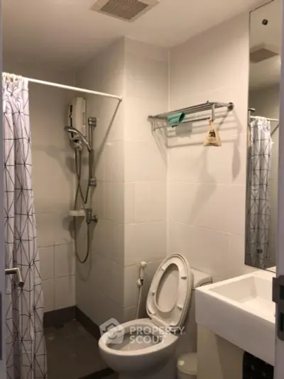 Compact bathroom with shower and modern fixtures in a cozy apartment.