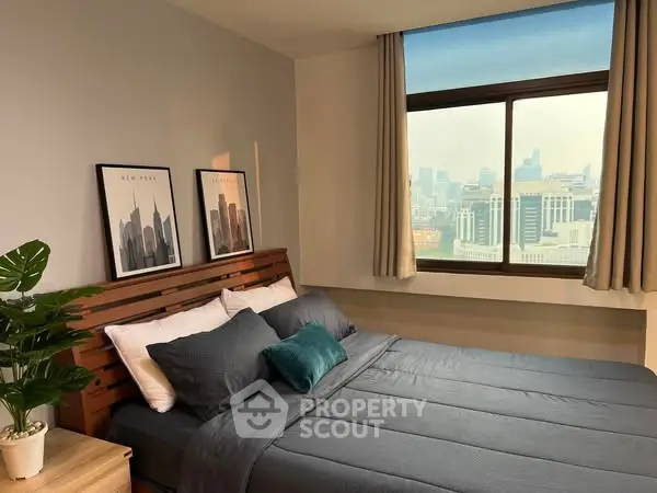 Modern bedroom with city view, stylish decor, and natural light.