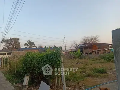 Spacious land plot with lush greenery and potential for development in a serene neighborhood.