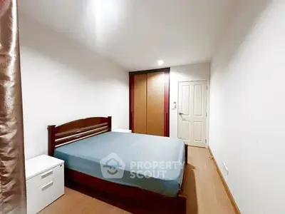Cozy bedroom with wooden flooring and built-in wardrobe, perfect for restful nights.