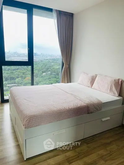 Modern bedroom with large window offering stunning city view and natural light.