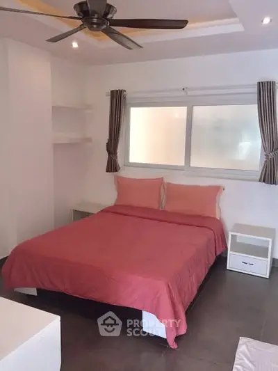 Cozy bedroom with modern ceiling fan and stylish decor, perfect for relaxation.