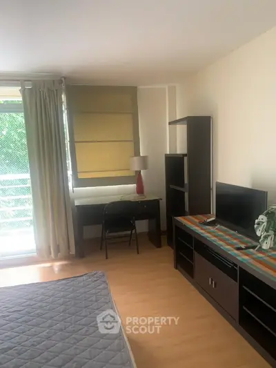 Cozy bedroom with study area and balcony access in modern apartment