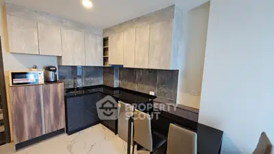 Modern kitchen with sleek cabinets and black countertops in a stylish apartment.