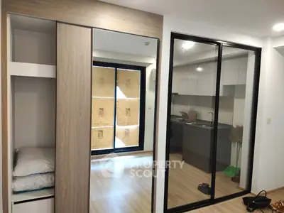 Modern apartment interior with sleek kitchen and mirrored wardrobe