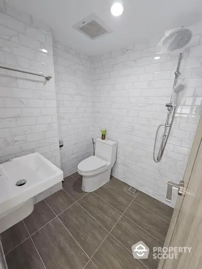 Modern bathroom with white brick-style tiles and sleek fixtures, featuring a spacious shower area and ceramic flooring for a clean, contemporary look.