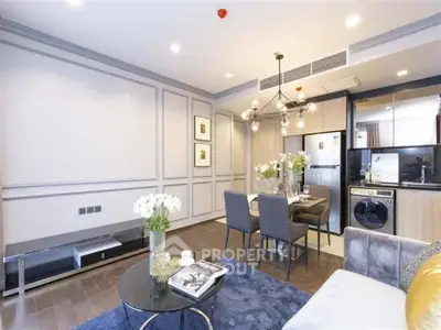 Modern living room with dining area and kitchen, featuring elegant decor and contemporary appliances.