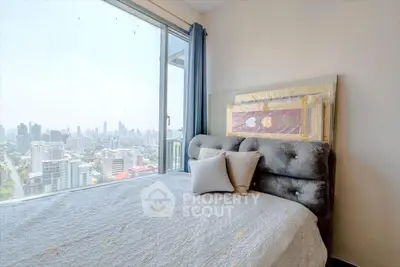 Spacious bedroom with stunning city view and cozy decor in modern apartment.