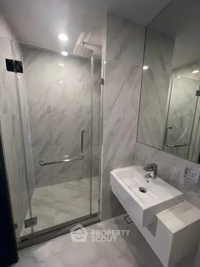Modern bathroom with glass shower and sleek sink in luxury apartment