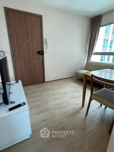 Cozy living room with modern furniture and large window in a stylish apartment.