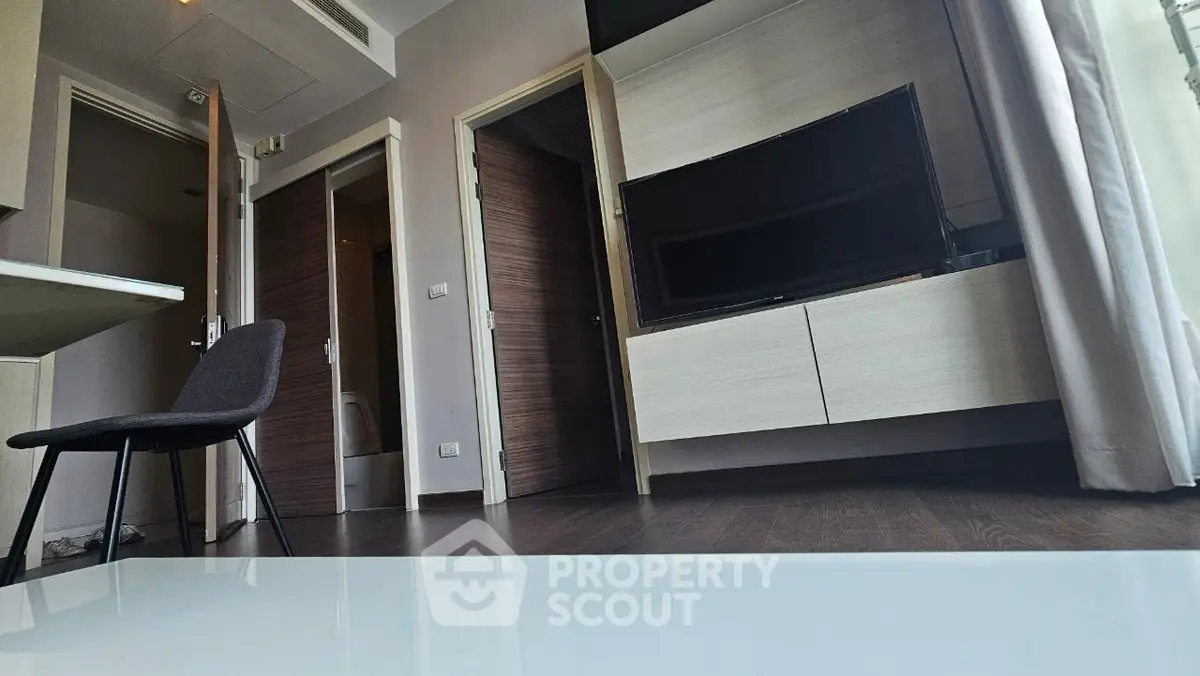 Modern living room with sleek furniture and large TV, showcasing contemporary interior design.