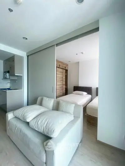 Modern studio apartment with cozy living area and sliding door to bedroom