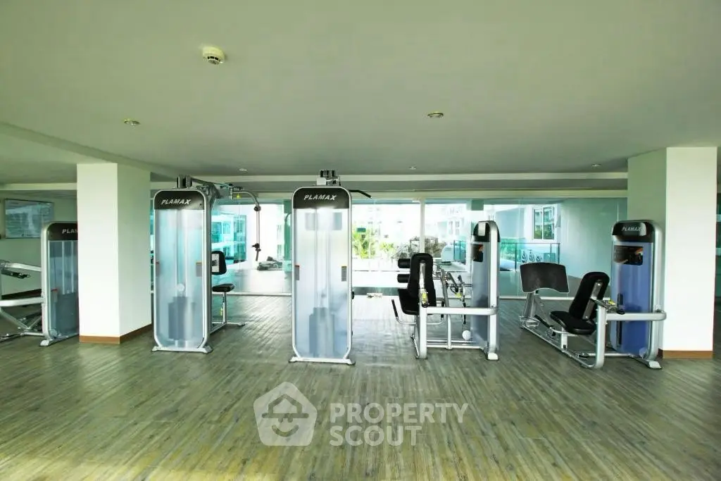Spacious modern gym with state-of-the-art equipment and large windows offering a bright and airy atmosphere.