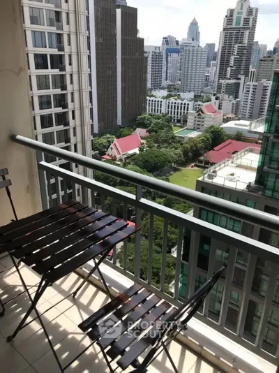 Stunning cityscape view from a high-rise balcony with outdoor seating.