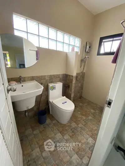 Modern bathroom with stylish tiles and glass block window