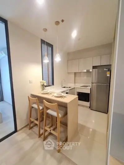 Modern kitchen with sleek design, featuring a breakfast bar and stainless steel appliances.