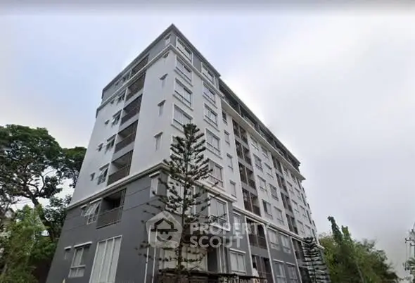 Modern multi-story residential building with sleek design and large windows.