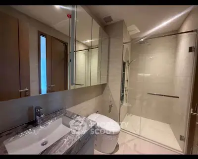 Luxurious modern bathroom with glass shower and elegant fixtures.