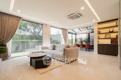 Luxurious living room with modern decor and garden view, featuring elegant furniture and ample natural light.