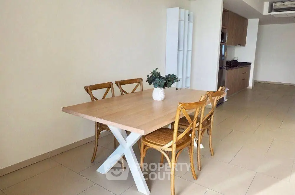 Spacious dining area with wooden table and chairs in modern apartment