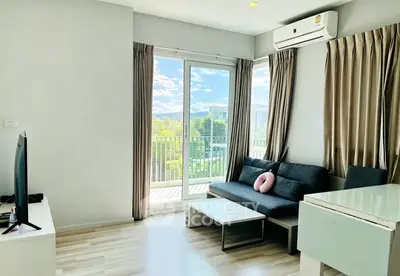 Modern living room with balcony view, featuring sleek furniture and abundant natural light.
