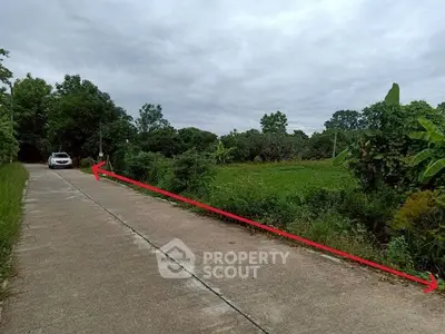 Scenic rural road with lush greenery and a parked car, ideal for countryside living.