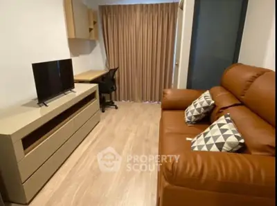 Cozy living room with leather sofa, TV stand, and study desk, perfect for relaxation and work.