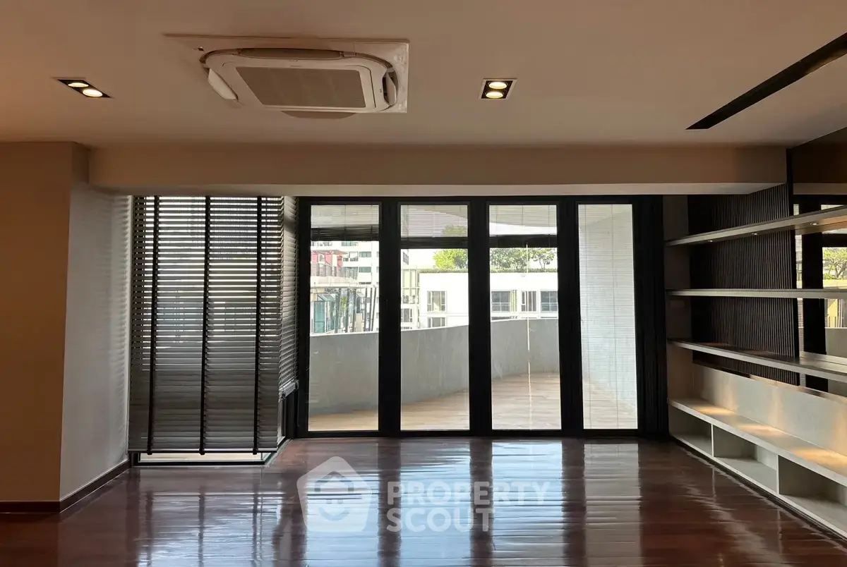 Spacious modern living room with large windows and balcony access