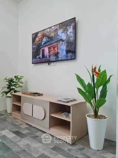 Modern living room with wall-mounted TV and stylish plants