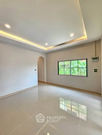 Spacious modern living room with large window and recessed lighting