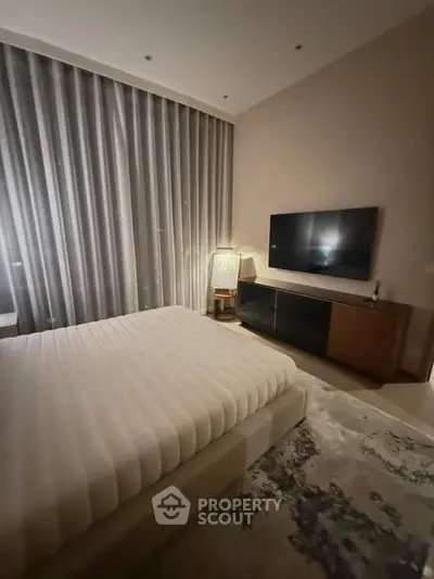 Luxurious bedroom with modern decor and large TV